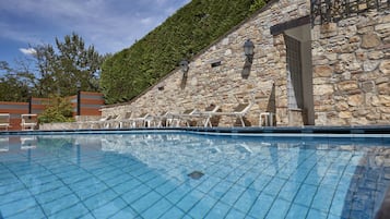 Una piscina al aire libre de temporada, sillones reclinables de piscina