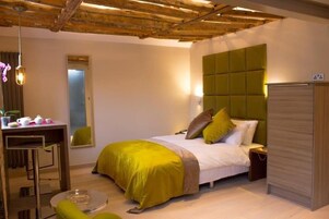 A bedroom with a bed, bedside table, and a green headboard.