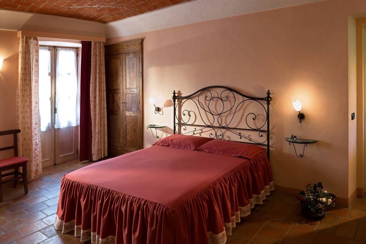 Une chambre à coucher avec un lit, une chaise, une table de chevet et une plante en pot.