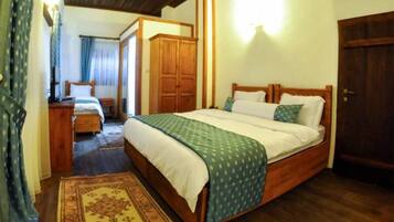 A bedroom with a wooden bed, a wardrobe, a desk, and a chair.