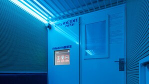 Une pièce avec un lit superposé, un panneau de contrôle et une porte avec une fenêtre.