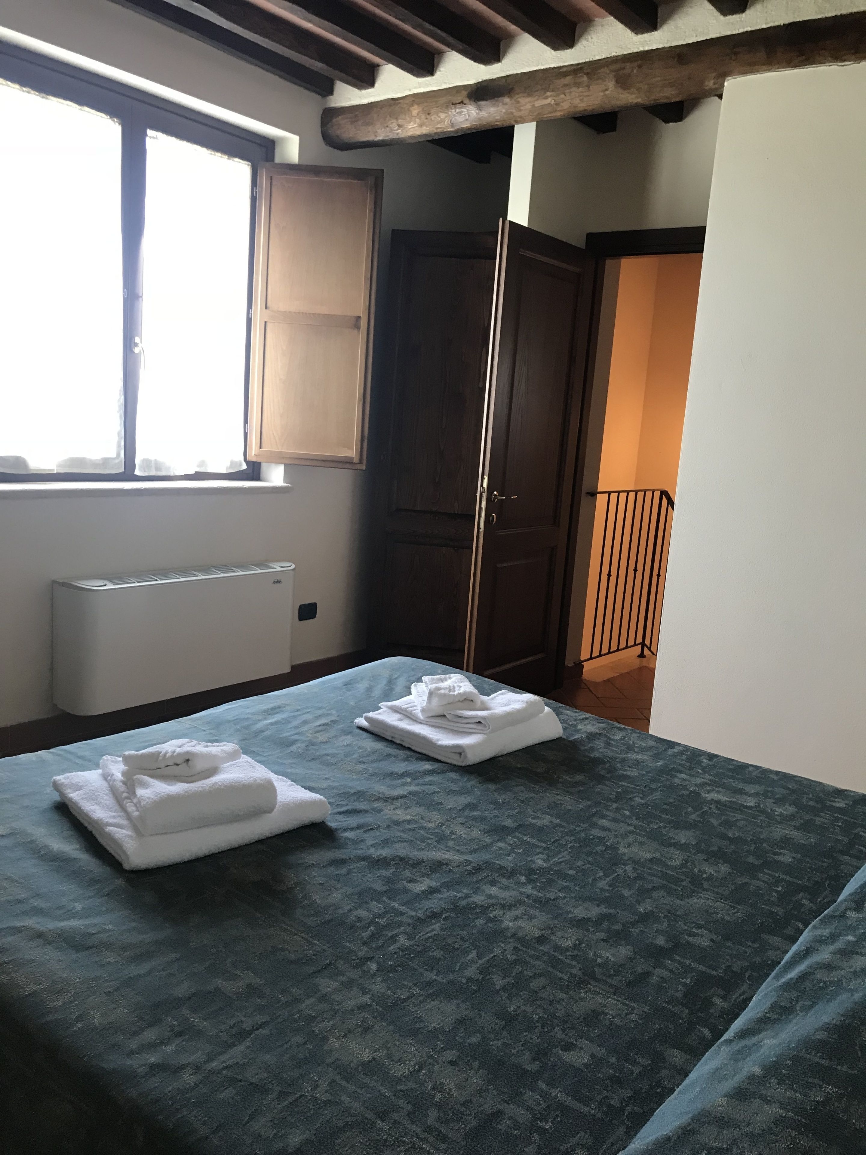 A room with a bed, a radiator, a window, and a door.