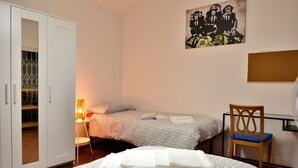 A bedroom with a bed, a chair, a wardrobe, and a wall-mounted artwork. - Ariete (Florence)