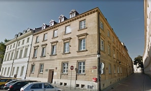 A multi-story building with a classical architectural style, featuring a symmetrical facade with evenly spaced windows and a central entrance.