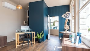 Un espacio de oficina moderno con un escritorio de madera, una computadora, una planta en maceta y una lámpara.