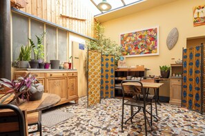 Una cocina acogedora con armarios de madera, un comedor con mesa y sillas, y piso de baldosas.
