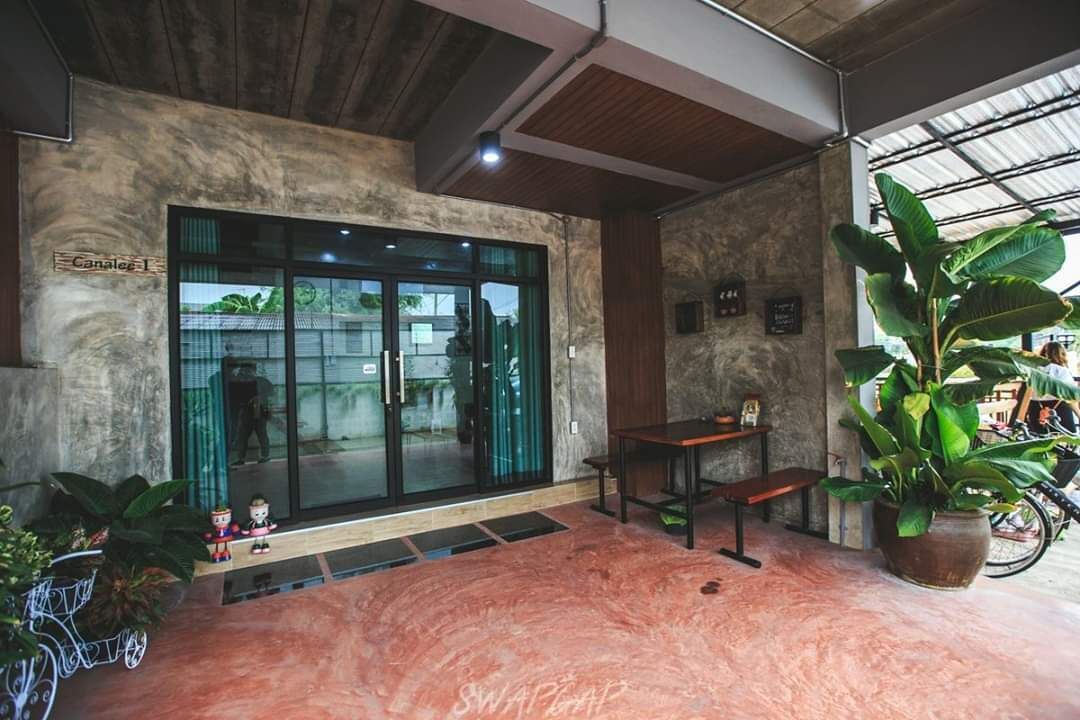 A modern interior with a reception desk, a large glass door entrance, and potted plants.