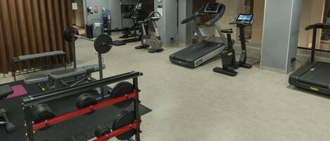A gym with treadmills, a weight bench, and various exercise machines.