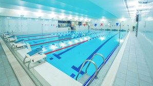 Una larga piscina cubierta con separadores de carril, numerados del 1 al 5, y un bloque de salida etiquetado '1'.