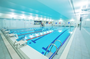 Ein langer, überdachter Schwimmbereich mit Bahnen, die von 1 bis 5 nummeriert sind, und einem Startblock mit der Aufschrift '1'.