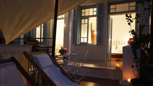 A terrace with lounge chairs, a table, and potted plants. - Live in Athens, Thiseio Historic House (Athens)