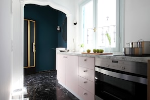 Una cocina con encimera de mármol, horno doble y ventana con vistas al exterior.