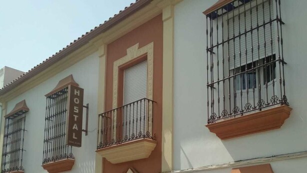 Un edificio de dos pisos con un cartel que indica que es un albergue.