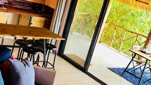 Un salon moderne comprenant un canapé, une table basse avec des livres et un coin repas avec une table et des chaises.