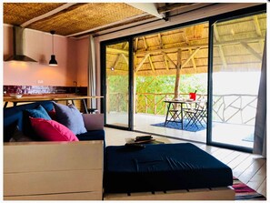 A room with a bed, a desk, and a large window.