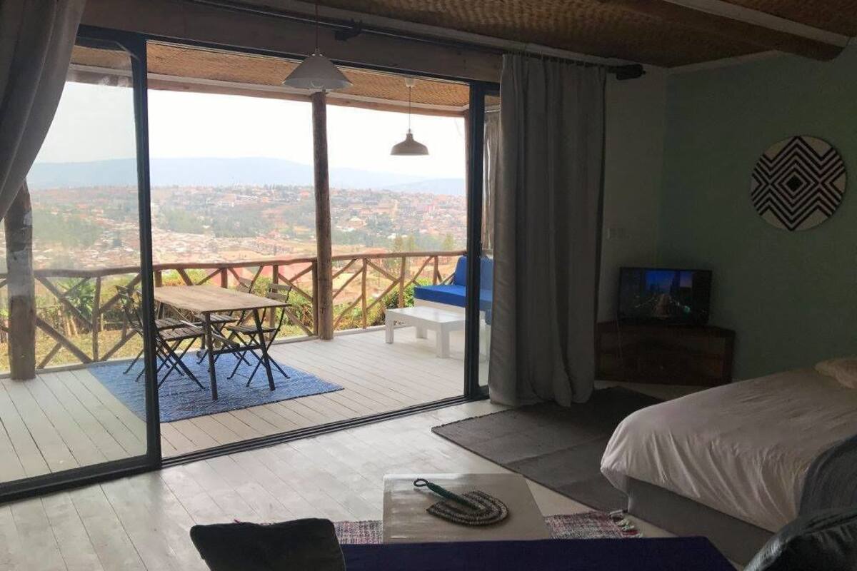 A bedroom with a large sliding glass door leading to an outdoor patio with a table and chairs.