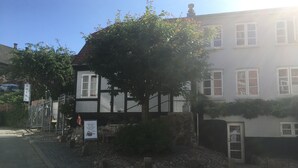 A traditional half-timbered building with a stone foundation, a cobblestone pathway, and a sign indicating a hotel. - Stephansens Hotel (Randers)