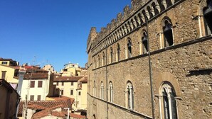 Un edificio histórico de piedra con ventanas de arco y un alero merodeado.