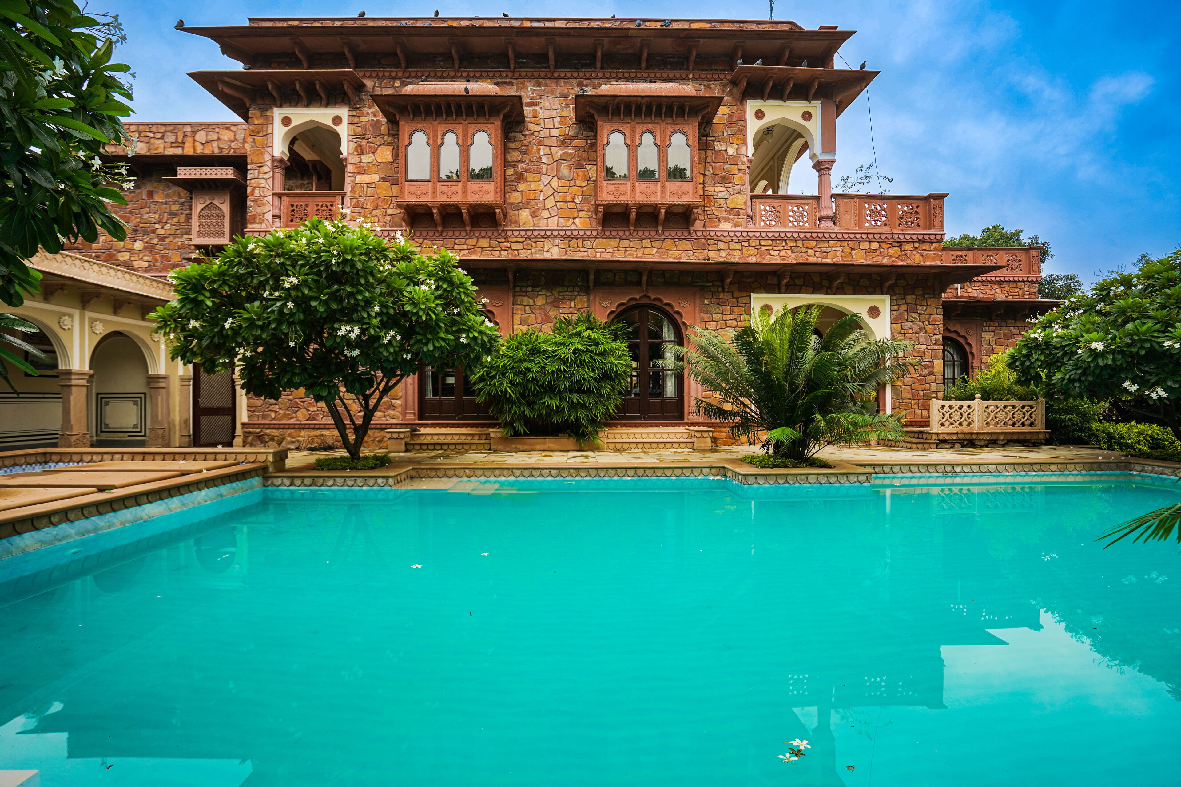 A traditional building with a swimming pool in front.