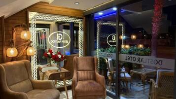 Una habitación de hotel moderna con una zona de estar acogedora, un espejo grande con iluminación y vistas a través de un ventanal.
