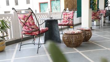 A terrace with wicker furniture and a tiled floor.
