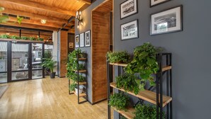 A modern interior with wooden beams, potted plants, and framed pictures on the walls. - Timber Boutique Hotel (Tbilisi)