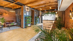 A spacious room with wooden beams, a brick wall, and a wooden reception desk. - Timber Boutique Hotel (Tbilisi)