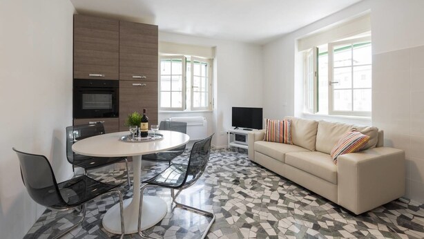 A modern living room with a round dining table, a sofa, and a TV. - Buonarroti (Florence)