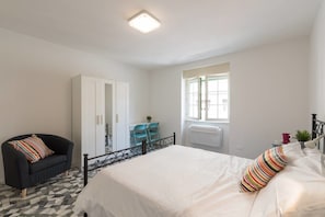 A bedroom with a bed, a chair, a desk, and a wardrobe. - Buonarroti (Florence)