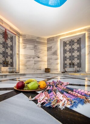 A modern interior with a marble floor, a fruit bowl, and a colorful blanket. - KONAK PARK HOTEL (Yomra)