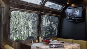 A cozy interior with a table, a bowl of fruit, and a book titled "AIRSTREAM."