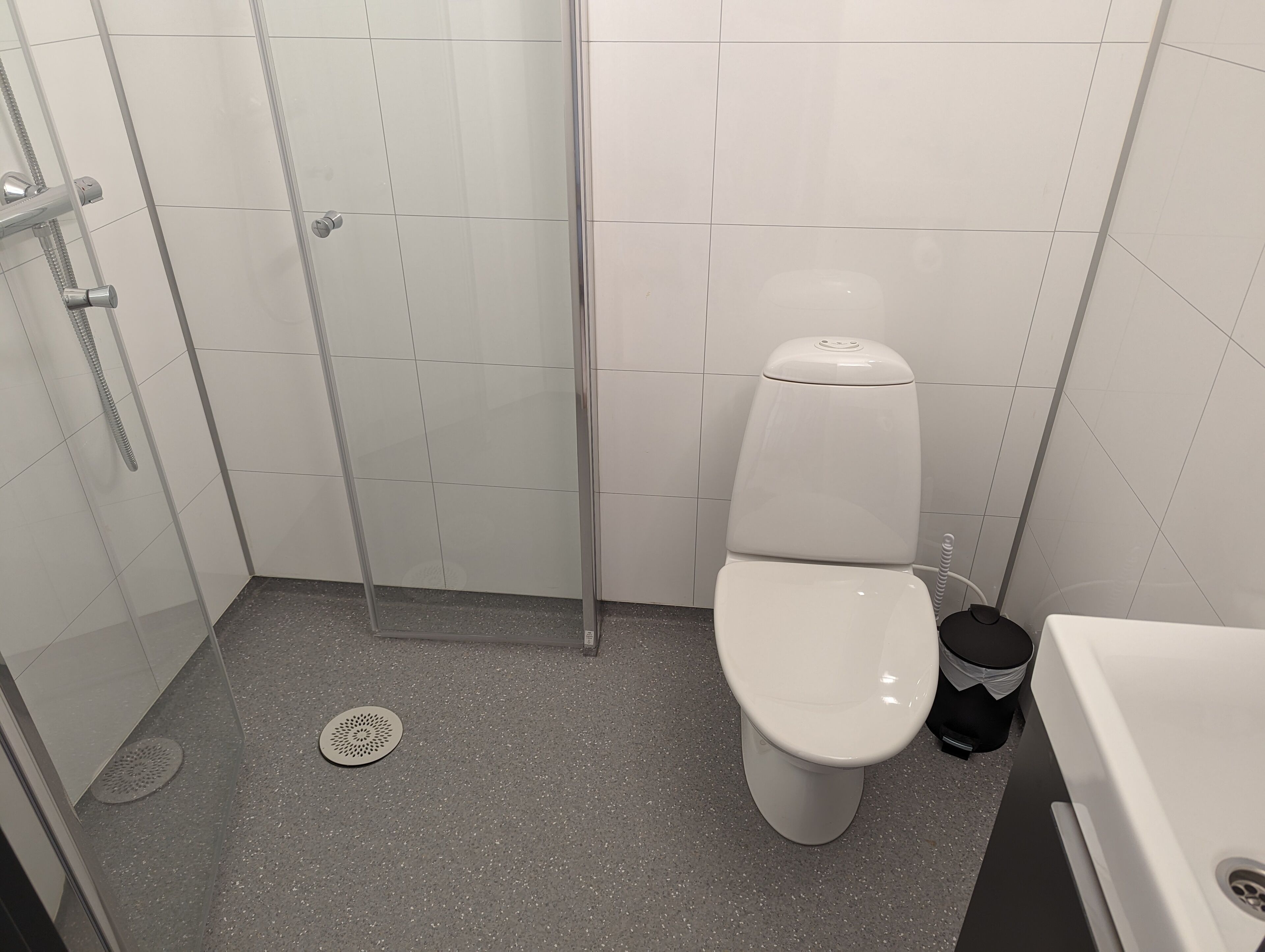 A bathroom with a shower, toilet, and sink.
