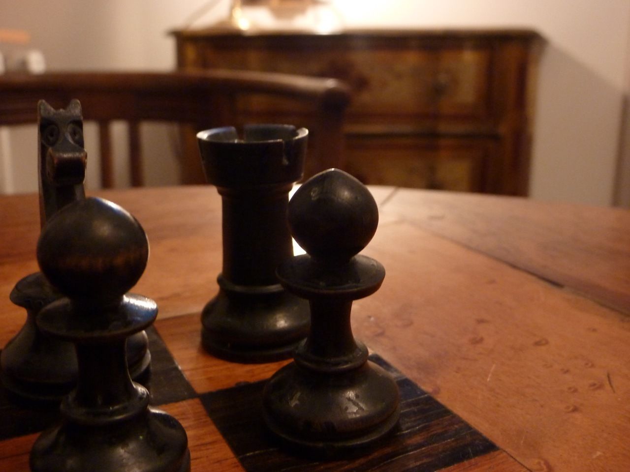 A wooden table with chess pieces.