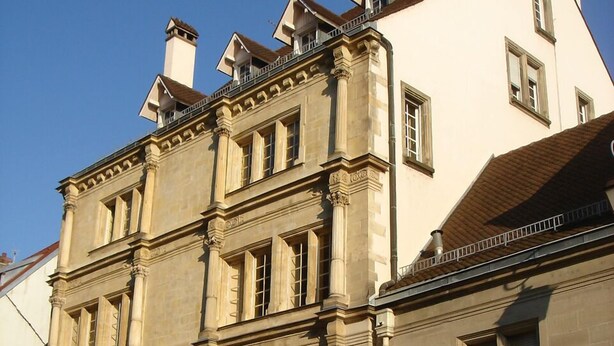 A historic building with a classic architectural style, featuring multiple windows and a prominent entrance.