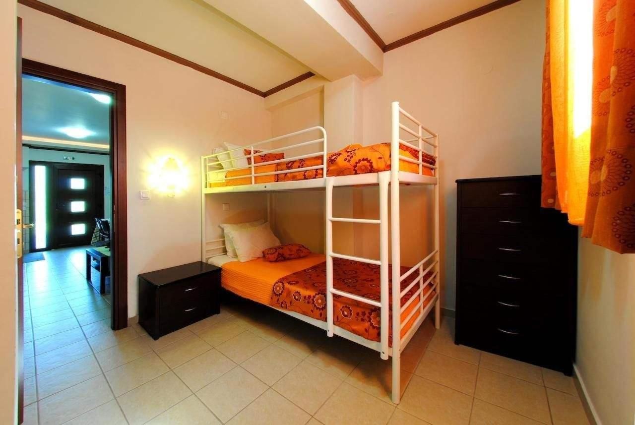 A bunk bed room with a desk and a dresser.