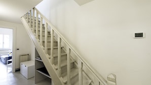 A staircase with a white handrail and a white wall.