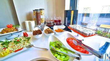 A buffet table with various dishes and condiments.