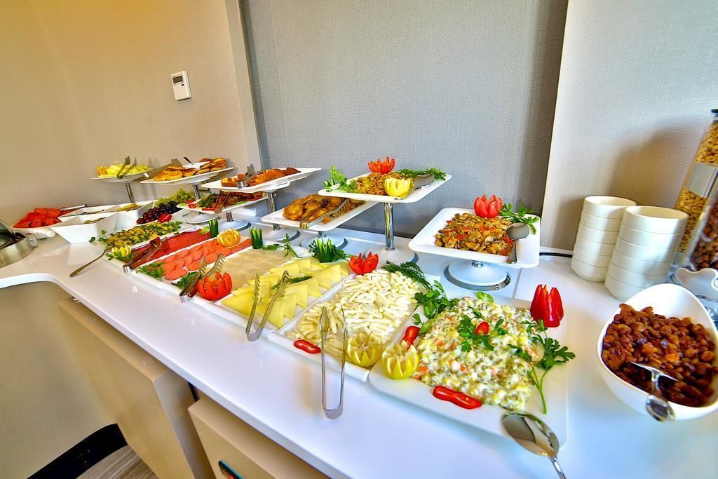 Buffet com diversos pratos, incluindo frutas, legumes e saladas.