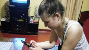 A person sitting on a red couch using a smartphone.