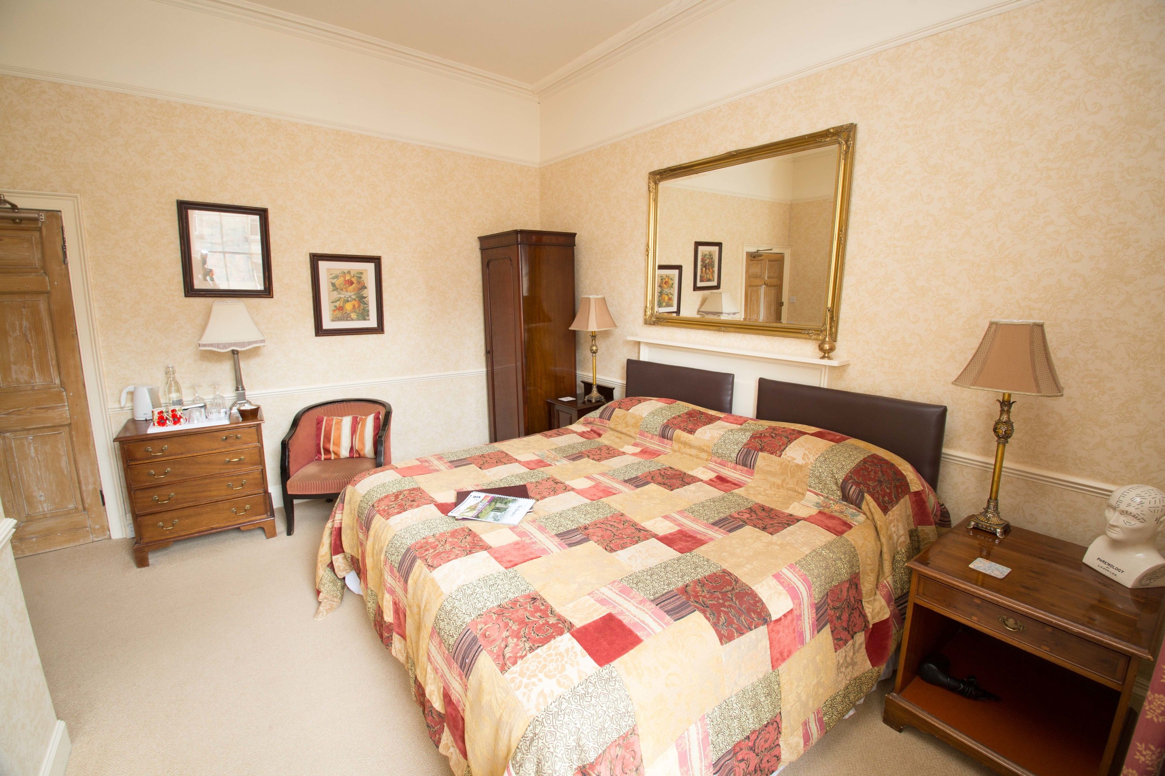 A neatly arranged bedroom with a large bed, a dresser, a chair, and a nightstand.