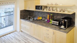 Een keuken met een magnetron, koffieapparaat en diverse keukenbenodigdheden.