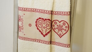 Een handdoek met decoratieve hartmotieven en kantbiesen.