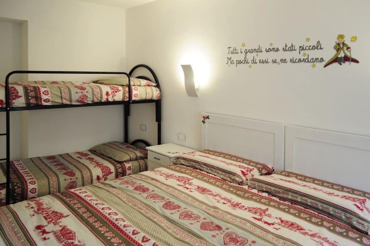 Une chambre de dortoir avec des lits superposés et une décoration murale.