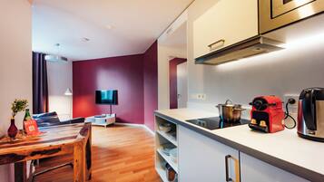 A modern kitchen with a microwave, coffee maker, and kettle.