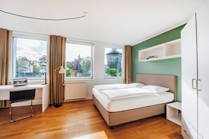 A modern hotel room with a bed, desk, and computer. - Brera Serviced Apartments Nürnberg (Nuremberg)
