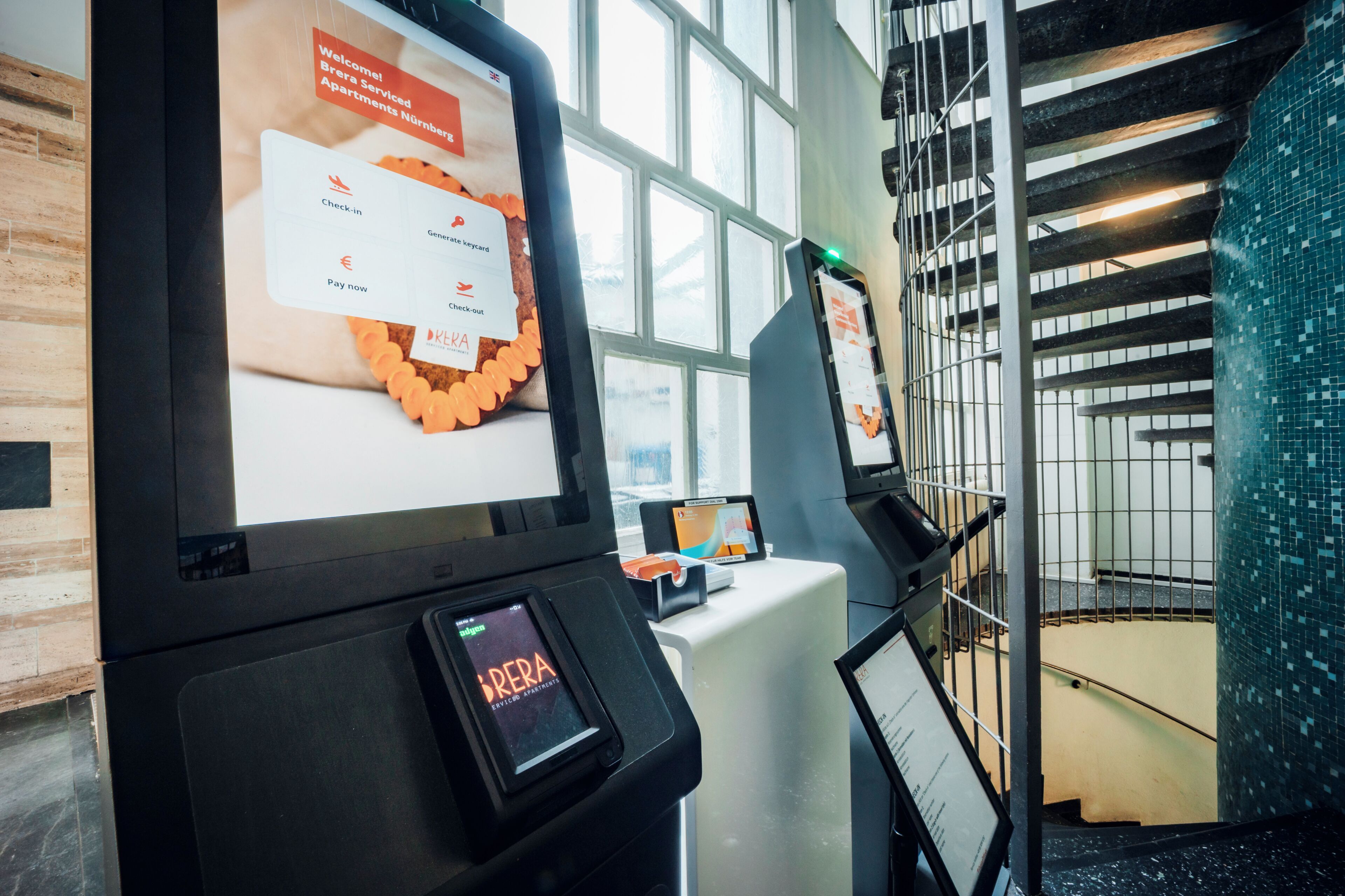 Digitaalinen infopiste, jossa on näyttö, joka esittää sisäänkirjautumisen käyttöliittymän palveluhuoneistoja varten.