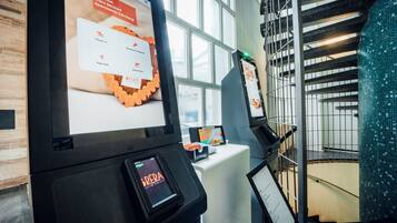 A digital kiosk with a screen displaying a check-in interface for serviced apartments.