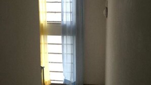 A narrow stairway leading to a room with a window covered by a blue curtain. - Hostel Bella Rimini (Rimini)