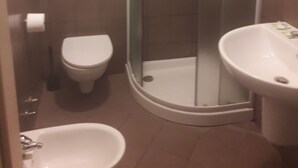 A bathroom with a glass-enclosed shower, a toilet, and a sink. - Hostel Bella Rimini (Rimini)