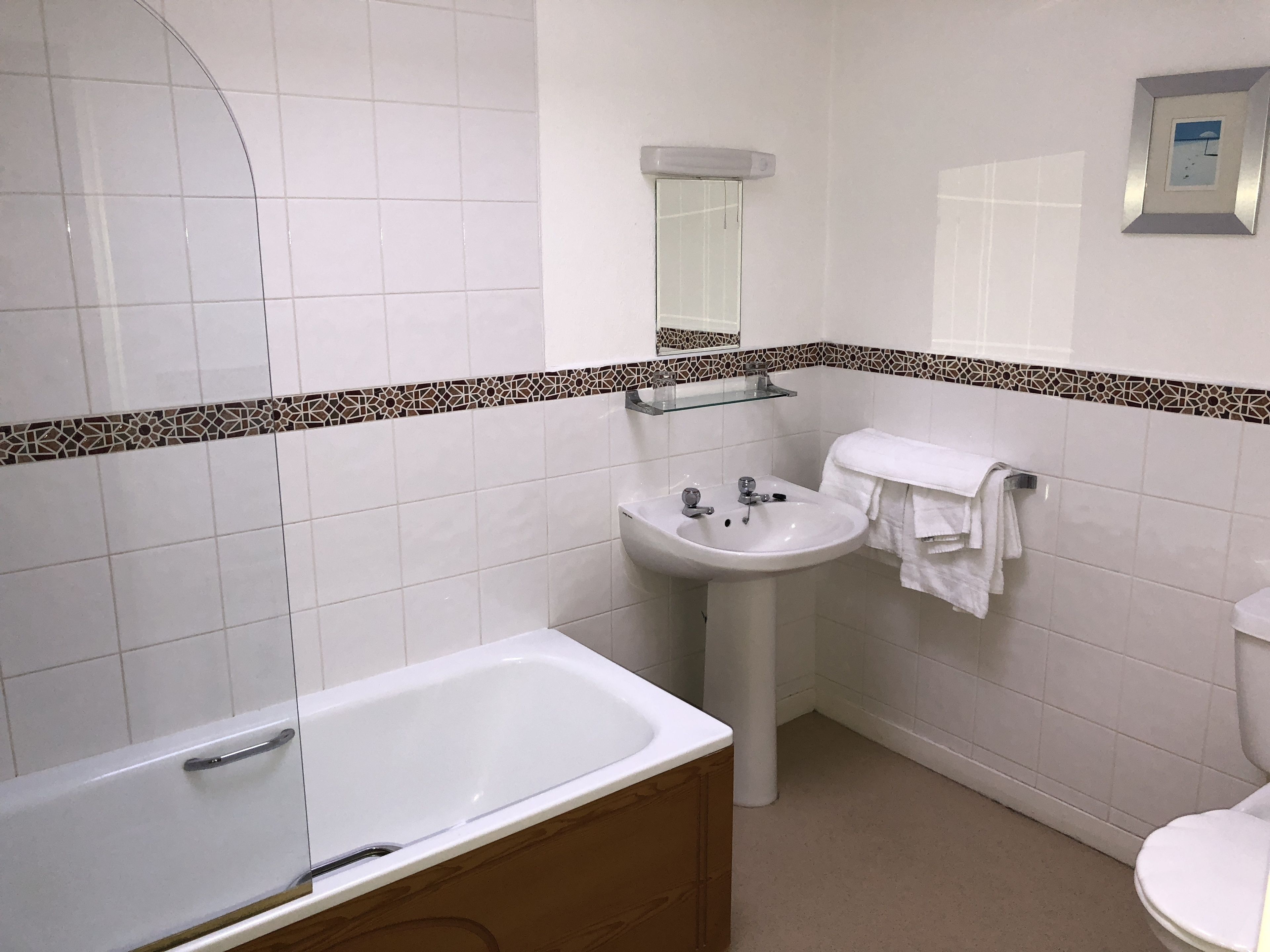 Un baño con bañera, lavamanos e inodoro.